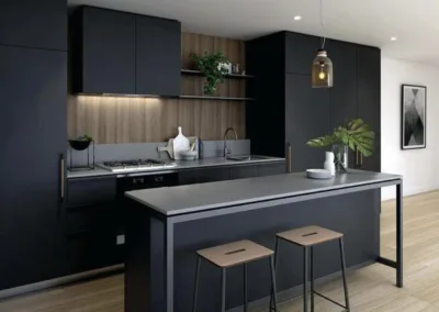 A modern kitchen with black cabinets and wooden floors.